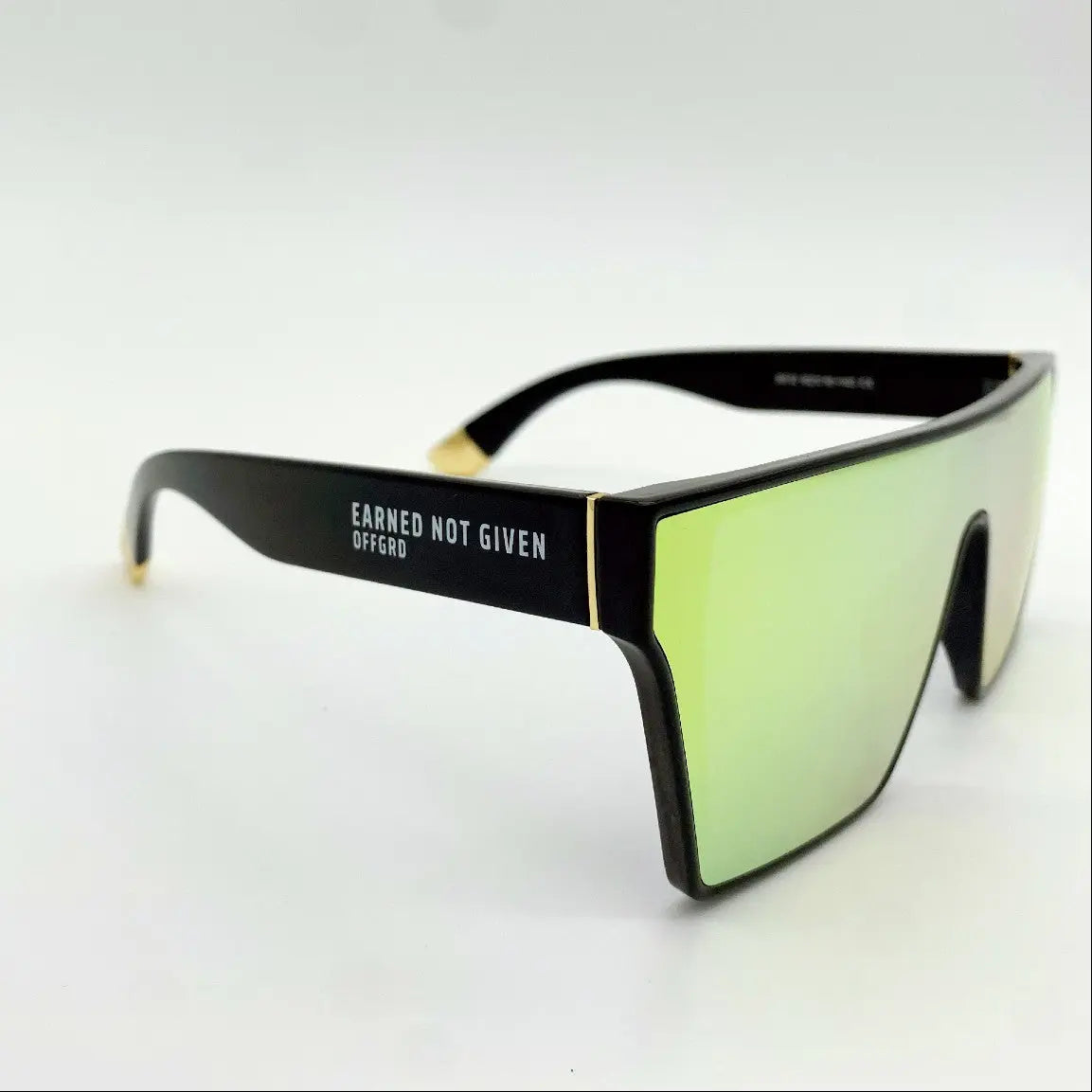 Sunglasses with a black frame and gold lenses on a white background
